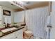Well-lit bathroom featuring a shower, vanity with a dark countertop and framed mirror at 4108 S Rifle Way, Aurora, CO 80013