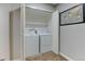 Convenient laundry closet with a stacked washer and dryer, plus storage shelves at 4108 S Rifle Way, Aurora, CO 80013