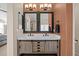 Bright bathroom featuring a double vanity, modern mirrors, and sconce lighting at 1271 Berganot Trl, Castle Pines, CO 80108