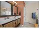 Bright bathroom featuring a double vanity, modern mirrors, and sconce lighting at 1271 Berganot Trl, Castle Pines, CO 80108