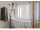 Bright bathroom featuring a modern soaking tub and natural light from the window at 1271 Berganot Trl, Castle Pines, CO 80108
