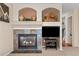 Close-up of fireplace with decorative mantel and flanking shelves, plus a view of the staircase at 1271 Berganot Trl, Castle Pines, CO 80108