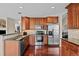 Updated kitchen with stainless steel appliances, granite countertops, and cherry wood cabinets at 1271 Berganot Trl, Castle Pines, CO 80108