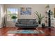 Comfortable living room with a black sofa, hardwood floors, and bright windows at 1271 Berganot Trl, Castle Pines, CO 80108
