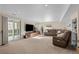Spacious living room with recessed lighting, a comfortable brown leather couch, and access to a patio at 1271 Berganot Trl, Castle Pines, CO 80108