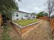 Landscaped backyard featuring a raised lawn area, wooden deck, and wood fence for privacy at 1390 W 78Th Cir, Denver, CO 80221