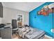 Cozy bedroom with a blue accent wall, comfortable bed, and a spacious desk area at 1390 W 78Th Cir, Denver, CO 80221