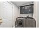 A well-lit laundry room with modern appliances and overhead cabinets for storage at 1390 W 78Th Cir, Denver, CO 80221
