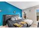 Comfortable main bedroom featuring a large bed, blue accent wall, and ample natural light at 1390 W 78Th Cir, Denver, CO 80221