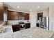 A modern kitchen featuring granite countertops, stainless steel appliances, and dark wood cabinets at 7232 Shavano Ave, Frederick, CO 80504