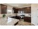 A modern kitchen with stainless steel appliances, dark wood cabinets and granite countertops at 7232 Shavano Ave, Frederick, CO 80504
