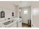 Bright laundry room featuring modern appliances, wire shelving, and a window with neighborhood views at 7232 Shavano Ave, Frederick, CO 80504