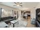 Open-concept living room with a gray sofa, dining area, and adjacent kitchen with hardwood-style floors at 7232 Shavano Ave, Frederick, CO 80504