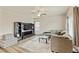 Cozy living room with a gray sofa, TV, media center, ceiling fan, and hardwood-style floor at 7232 Shavano Ave, Frederick, CO 80504