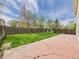 Green backyard with a large patio, bordered by a wooden fence and mature trees at 5010 E 100Th Dr, Thornton, CO 80229