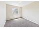 A simple, carpeted bedroom with a window offering natural light at 5010 E 100Th Dr, Thornton, CO 80229