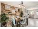 Inviting dining room with decorative brick wall and open to the kitchen space, with modern light fixture at 10457 Owens Cir, Broomfield, CO 80021