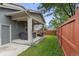 Backyard covered patio with a hot tub and outdoor seating, bordered by a red wooden fence at 8464 E 55Th Pl, Denver, CO 80238