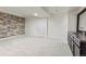 Partially finished basement featuring neutral carpet and a textured stone accent wall, with access to plumbing for a wet bar at 8464 E 55Th Pl, Denver, CO 80238