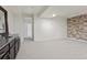 Partially finished basement with a wet bar, neutral carpet, and a textured stone accent wall at 8464 E 55Th Pl, Denver, CO 80238