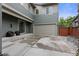 Home exterior showcasing a two-car garage, sliding glass door, and modern two-tone siding at 8464 E 55Th Pl, Denver, CO 80238