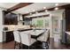 Open kitchen featuring dark wood cabinets, granite countertops, stainless steel appliances, and bar seating at 8464 E 55Th Pl, Denver, CO 80238