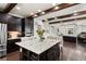 A gourmet kitchen featuring dark wood cabinets, a granite island, and wood beam ceilings at 8464 E 55Th Pl, Denver, CO 80238