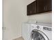 Convenient laundry room with a washer and dryer and upper cabinets for storage at 8464 E 55Th Pl, Denver, CO 80238