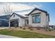 Well-designed home exterior with black trim and stone accents, offering modern elegance at 6586 S Lewis Ct, Littleton, CO 80127