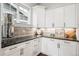 Gourmet kitchen featuring white cabinetry, stylish backsplash, and modern fixtures at 6586 S Lewis Ct, Littleton, CO 80127
