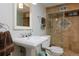 Beautiful bathroom featuring travertine shower, white porcelain sink and toilet, decorative details at 239 Ash St, Denver, CO 80220