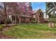 Charming two-story brick home with a lush front lawn and flowering tree at 239 Ash St, Denver, CO 80220