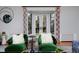 Stylish living room featuring green chairs, unique mirror, and French doors with views of the backyard at 239 Ash St, Denver, CO 80220