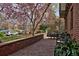Outdoor patio space featuring a brick perimeter, stone flooring, classic metal outdoor furniture and flowering trees at 239 Ash St, Denver, CO 80220