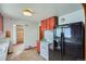 Compact kitchen featuring black refrigerator, white appliances, and bright red cabinets at 925 Quitman St, Denver, CO 80204