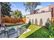 Backyard with a well-maintained lawn, small garden and patio seating area at 1833 E Jewell Ave, Denver, CO 80210