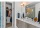 Contemporary bathroom features a double vanity, large mirror, and access to a walk-in closet at 1833 E Jewell Ave, Denver, CO 80210