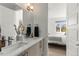 Bright bathroom with dual sink vanity and a door leading to the bedroom at 1833 E Jewell Ave, Denver, CO 80210
