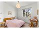 Cozy bedroom with a comfortable bed, desk, and a large window that provides natural light at 1833 E Jewell Ave, Denver, CO 80210
