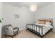 Cozy bedroom featuring a modern light fixture, comfortable armchair and crisp white walls at 1833 E Jewell Ave, Denver, CO 80210