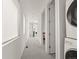 Well-lit hallway with laundry area and linen closet access, connecting various rooms on the upper level at 1833 E Jewell Ave, Denver, CO 80210