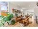 Bright living room features a brown leather sofa, hardwood floors, and stylish decor with a view into the open concept dining area at 1833 E Jewell Ave, Denver, CO 80210