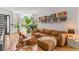 Cozy living room with leather sofa, hardwood floors, bookshelf, and large windows at 1833 E Jewell Ave, Denver, CO 80210