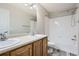 Bright bathroom boasts double sinks, a large mirror, and shower over tub at 17244 E Kansas Dr, Aurora, CO 80017