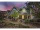 Charming home exterior with stone accents, covered porch, mature trees, and warm lighting at 17244 E Kansas Dr, Aurora, CO 80017