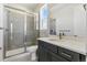 Bathroom with stand up shower with glass enclosure and vanity with modern fixtures and gray cabinetry at 5698 Farrier Pt, Castle Rock, CO 80104