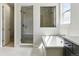 Modern bathroom featuring dual walk-in glass showers, a soaking tub, sleek fixtures, and tiled floors at 5698 Farrier Pt, Castle Rock, CO 80104