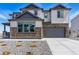 Beautiful two-story home featuring stone accents, gray siding, a two-car garage, and a concrete driveway at 5698 Farrier Pt, Castle Rock, CO 80104