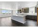 Bright, open kitchen features gray cabinets, stainless steel appliances, and a large island for entertaining at 5698 Farrier Pt, Castle Rock, CO 80104