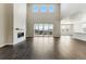 Bright living room featuring soaring ceilings, fireplace, hardwood floors, and access to outdoor deck at 5698 Farrier Pt, Castle Rock, CO 80104